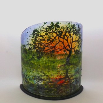 Oak tree in spring with sunset behind reflected in the canal