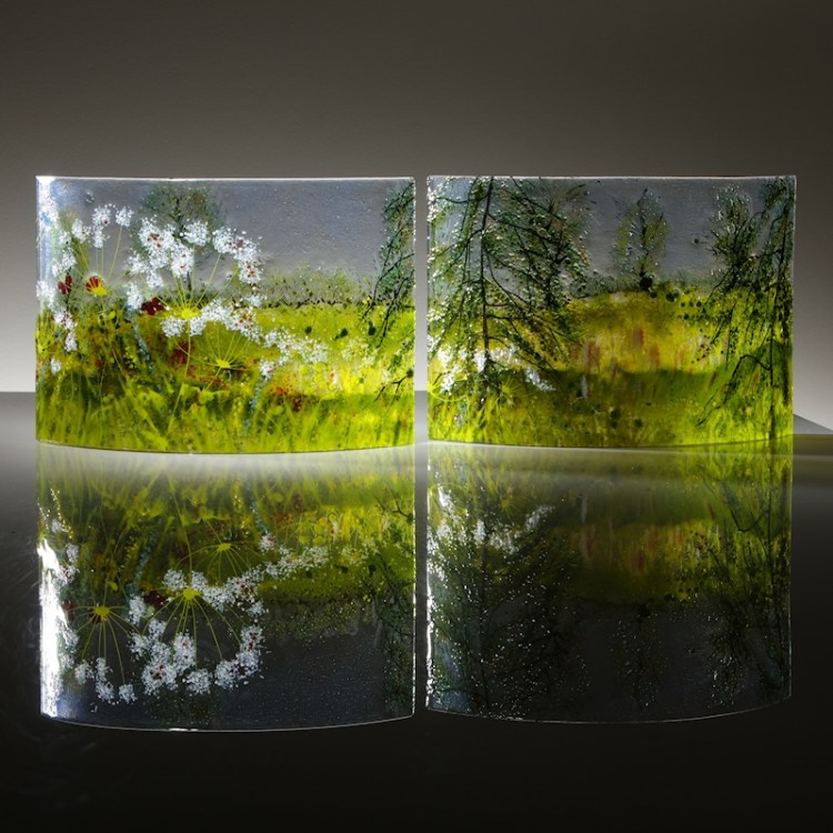 " curved glass sculpture showing trees. spring flowers and bullrushes.