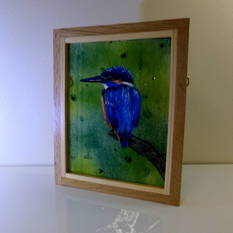 Fused glass picture of a kingfisher perched on a branch. Picture framed in oak.