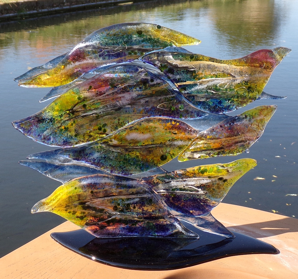 Glass sculpture with sections of glass representing the movement of water on the surface of the canal.