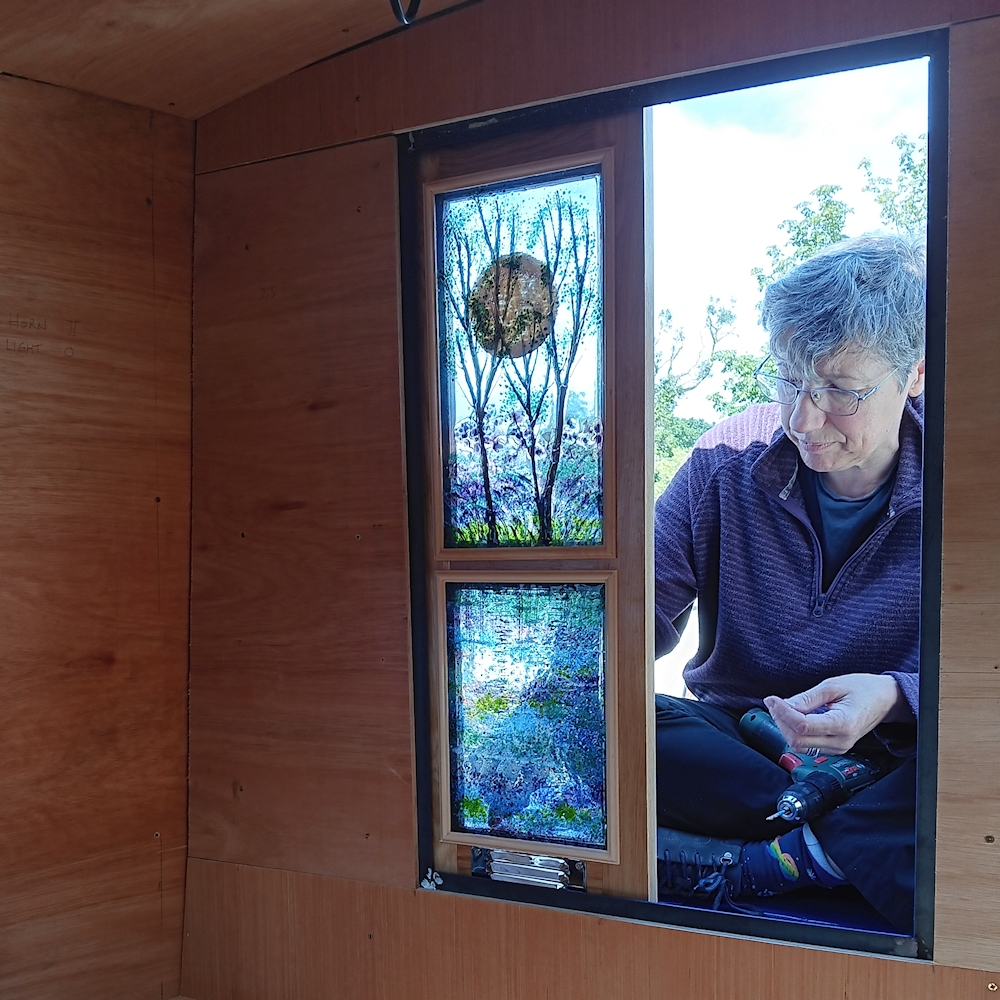 Kathryn sitting on the bow of the boat fitting the door panels.