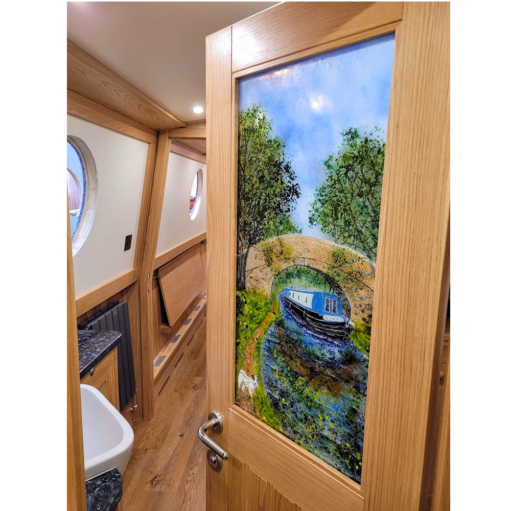 Fused glass door panel on narrowboat Dilly Dally showing the boat under a bridge with a dog on the towpath.