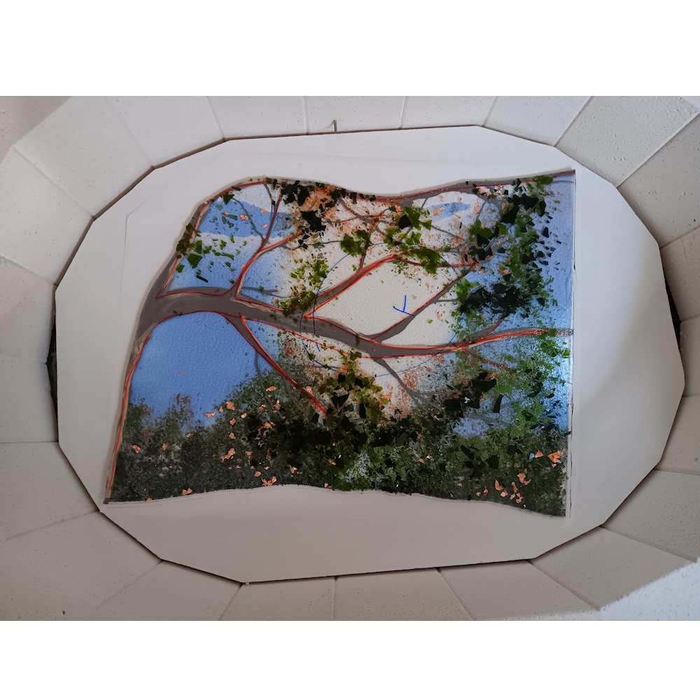 Tree branch section of glass in the kiln before firing with glass frit for the leaves.