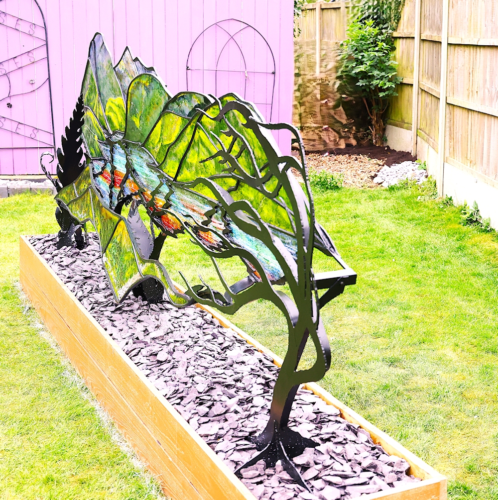 Garden Sculpture 'Kyles of Bute'. Black metal frame with coloured glass outlining the view of the loch.