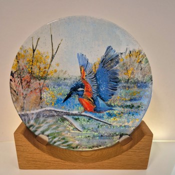 Fused glass disc mounted on a wooden base. The design is a Kingfisher landing on a snowy branch near the canal.