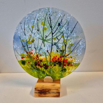 Glass disc sculpture on an oak stand, featuring cow parsley flowering .