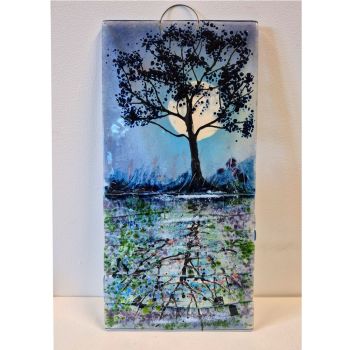 A wall hanging showing a tree reflected in the canal with the moon rising in the background.