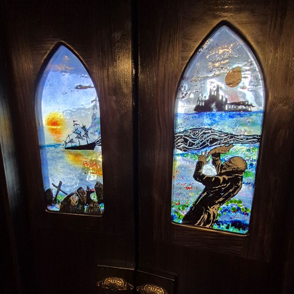 Two fused glass boat door panels featuring scenes from the film Nosferatu including Nosferatu, Whitby Abbey and the ship Dimeter.