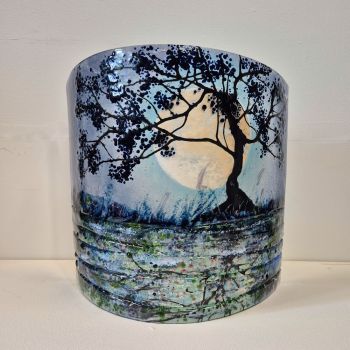 Fused curved fused glass sculpture. A night time scene with a tree in the foreground with the moon setting behind. The scene is reflected in the canal with textured glass representing patterns in the water.