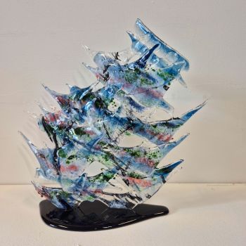 Abstract fused glass sculpture on a black glass base. Spiked glass in blue, green and pink colours. Based upon patterns in the canal